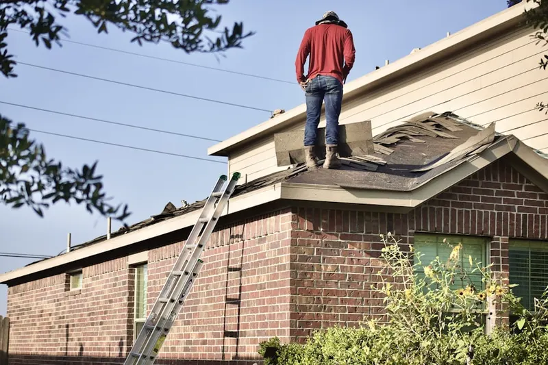 Professional roofer working on a residential roof in Angelica